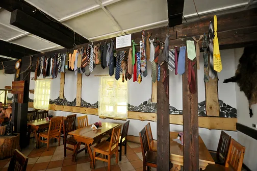 Sala Kominkowa w schronisku z wiszącymi krawatami odciętymi zbyt eleganckim turystom