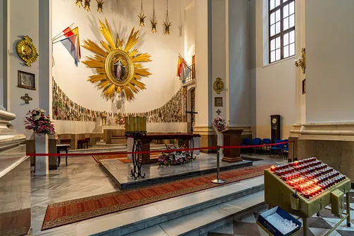Presbiterium jezuitów z ołtarzem posoborowym i kompozycją wotywną w tle.