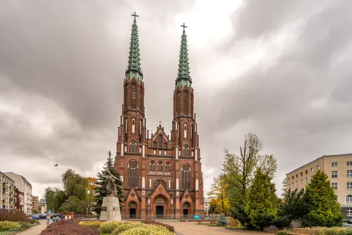 Dwurestauracyjna, neogotycka fasada bazyliki katedralnej św. Michała i św. Floriana w Warszawie z placu przed świątynią.