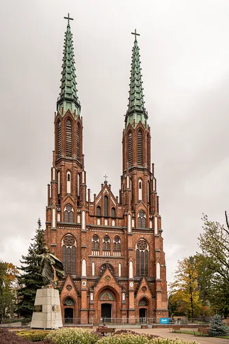 Monumentalna fasada bazyliki katedralnej św. Michała i św. Floriana w Warszawie z dwiema strzelistymi wieżami.