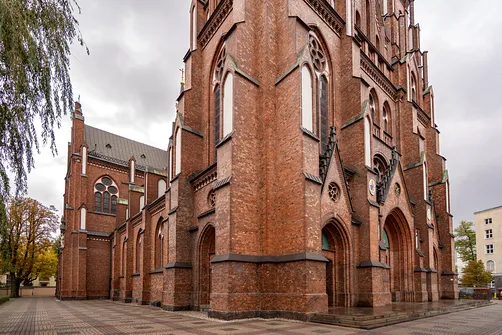 Ceglana elewacja boczna i monumentalny narożnik bazyliki katedralnej św. Michała i św. Floriana w Warszawie.