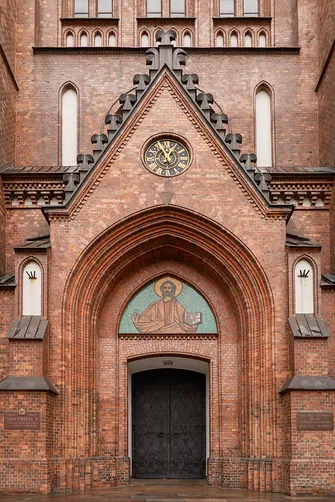 Portal wejściowy bazyliki katedralnej św. Michała i św. Floriana w Warszawie z mozaiką Chrystusa.