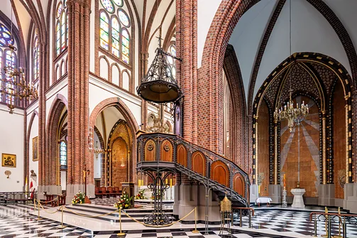 Wnętrze bazyliki katedralnej św. Michała i św. Floriana w Warszawie z widokiem na ambonę i baptysterium.