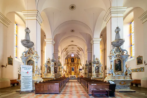 Barokowe wnętrze bazyliki Nawiedzenia NMP w Sejnach z widokiem na nawę główną i ołtarze boczne.