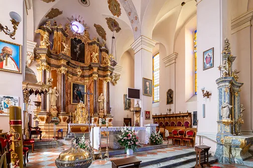 Widok na prezbiterium i ołtarz główny bazyliki w Sejnach z perspektywy nawy bocznej.