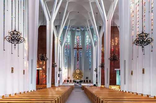 Nawa główna z rzędami ław w nowoczesnym wnętrzu konkatedry w Stalowej Woli.