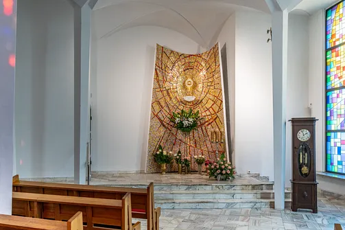 Ołtarz boczny z mozaiką i monstrancją w modernistycznym wnętrzu bazyliki w Stalowej Woli.