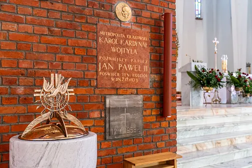 Pamiątkowa tablica poświęcona Karolowi Wojtyle na ceglanej ścianie bazyliki w Stalowej Woli.