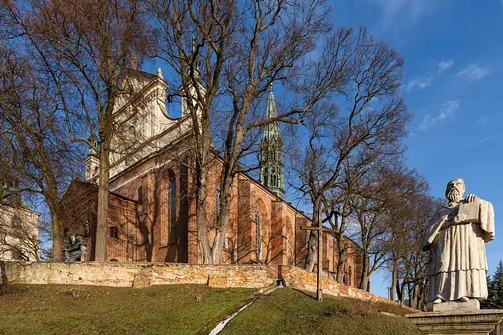 Pomnik bł. Wincentego Kadłubka na tle barokowej fasady katedry w Sandomierzu.