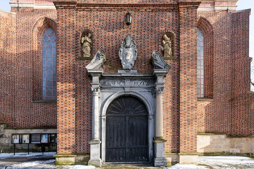 Barokowy portal wejściowy z kamiennymi rzeźbami w kruchcie zachodniej katedry w Sandomierzu.