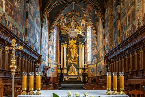 Prezbiterium sandomierskiej bazyliki katedralnej z ołtarzem głównym i bogatymi dekoracjami malarskimi.