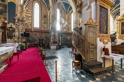Widok z podwyższenia prezbiterium na nawę boczną i schody ambony w bazylice w Sandomierzu.