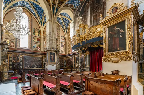 Drewniane ławy kościelne i złocony prospekt organowy w nawie katedry w Sandomierzu.