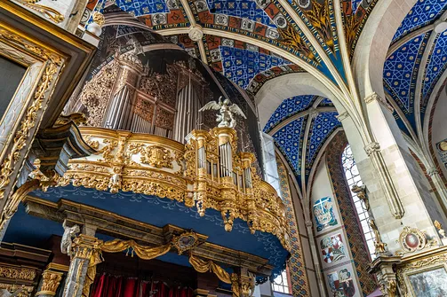 Zbliżenie na barokowy, bogato rzeźbiony i złocony prospekt organowy w katedrze w Sandomierzu.