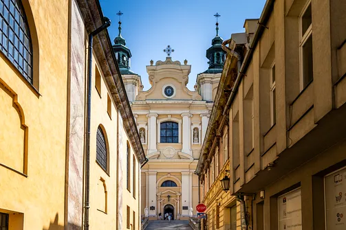 Fronton przemyskiego soboru archikatedralnego św. Jana Chrzciciela ujęty w kadrze między kamienicami.