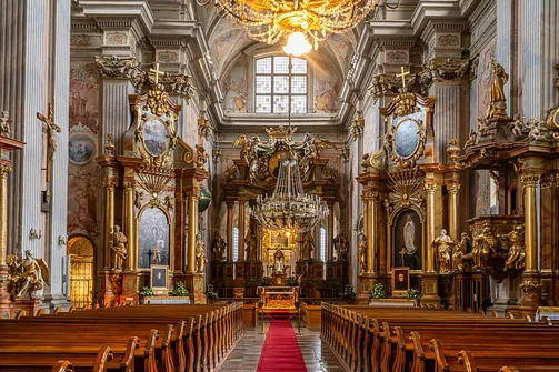 Perspektywa barokowego prezbiterium i ołtarzy bocznych w warszawskim kościele akademickim.