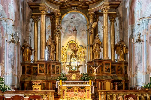 Barokowy ołtarz główny z tabernakulum i rzeźbami świętych w prezbiterium kościoła św. Anny w Warszawie.
