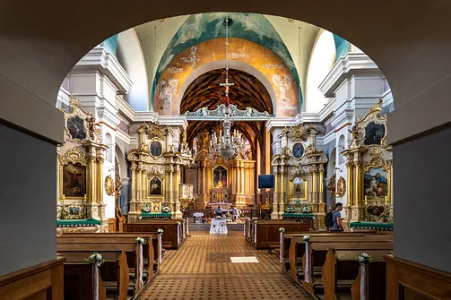 Widok przez arkadę na nawę główną, ołtarze boczne oraz prezbiterium rzeszowskiego kościoła farnego.