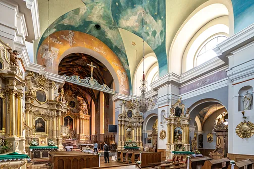 Perspektywa nawy głównej kościoła pw. św. Wojciecha i Stanisława w kierunku bogato zdobionego prezbiterium.