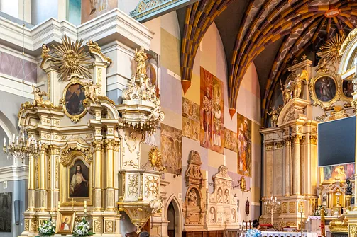 Barokowy ołtarz boczny i ambona z polichromią ścienną w tle we wnętrzu kościoła św. Wojciecha w Rzeszowie.