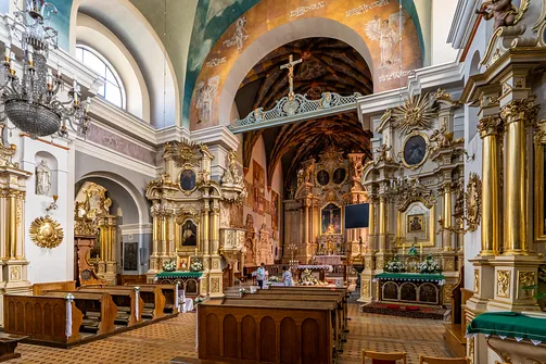 Perspektywa nawy głównej rzeszowskiej fary w kierunku barokowego prezbiterium z ławkami dla wiernych.