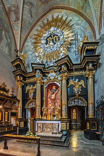 Barokowy ołtarz w Kaplicy Cudownego Krzyża w pełnej okazałości, zwieńczony promienistą glorią.