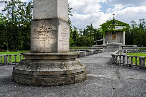 Kamienny postument obelisku na placu odpustowym z wyrytym cytatem biblijnym.
