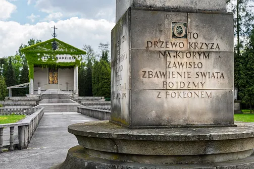 Druga strona kamiennego cokołu z inskrypcją o drzewie Krzyża na tle placu.
