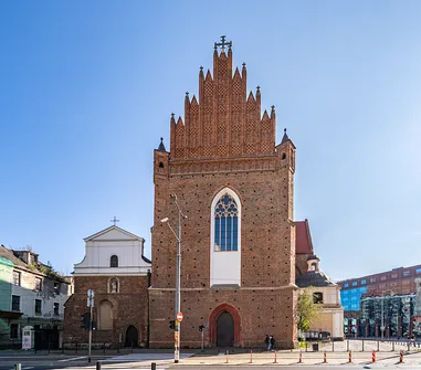 Fasada frontowa kościoła św. Wojciecha we Wrocławiu z monumentalnym ostrołukowym oknem i ozdobnym szczytem.