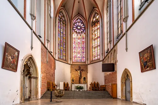 Ołtarz główny kościoła św. Wojciecha we Wrocławiu z widoczną architekturą prezbiterium i ostrołukowymi przejściami.