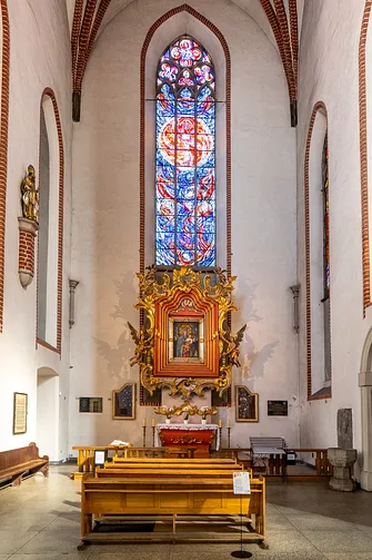 Ołtarz boczny w kościele św. Wojciecha we Wrocławiu z obrazem Matki Bożej Podkamieńskiej pod wysokim oknem.