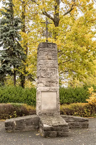 Obelisk przy warszawskiej konkatedrze z tablicą upamiętniającą osoby pochowane na dawnym cmentarzu Kamionkowskim.