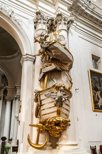 Zbliżenie na słynną ambonę-łódź z rzeźbą anioła, kotwicą i orłem na dziobie.