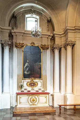 Klasycystyczny ołtarz boczny z obrazem sakralnym, flankowany przez korynckie kolumny.