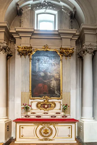 Inny ołtarz boczny w niszowej arkadzie, zwieńczony złoconymi akcentami i rzeźbami kapiteli.