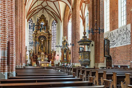 Barokowa ambona i ołtarz główny we wnętrzu trójnawowej katedry w Opolu.