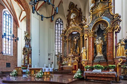 Barokowe ołtarze w otoczeniu gotyckich okien we wnętrzu kościoła katedralnego.