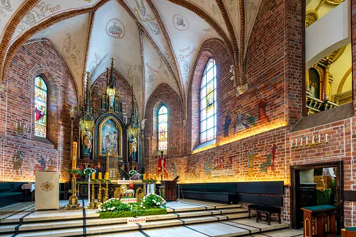 Ołtarz główny i dekoracje malarskie na ceglanych ścianach prezbiterium radomskiej fary.