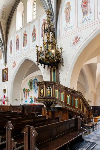 Misternie rzeźbiona ambona z baldachimem we wnętrzu radomskiej świątyni farnej.