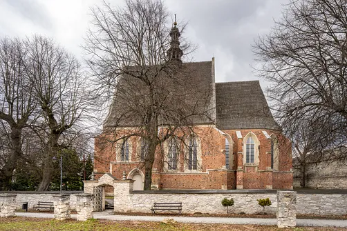 Widok na południową elewację kościoła św. Władysława w Szydłowie od strony otaczającego muru.