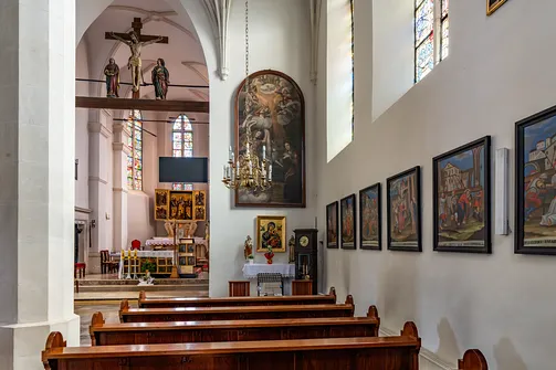 Wnętrze nawy kościoła św. Władysława w Szydłowie z widokiem na stacje Drogi Krzyżowej.
