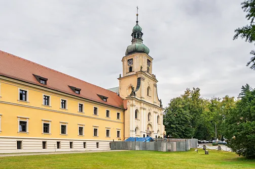 Barokowa fasada i wieża kościoła klasztornego w Rudach połączona z budynkiem dawnego opactwa.