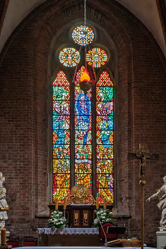 Barwny witraż w głównym oknie prezbiterium rudzkiej bazyliki nad tabernakulum.
