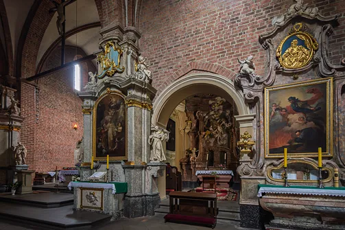 Barokowy ołtarz boczny przy ceglanym filarze nawy i otwarty portal do kaplicy.