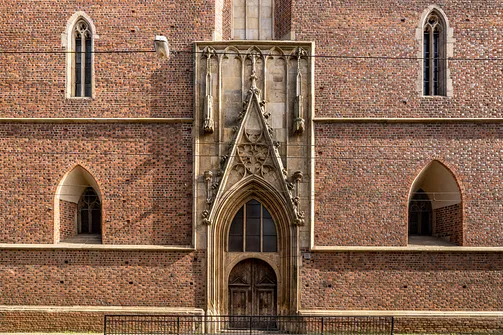 Gotycki portal ostrołukowy w ceglanej elewacji kościoła Najświętszej Maryi Panny na Piasku.
