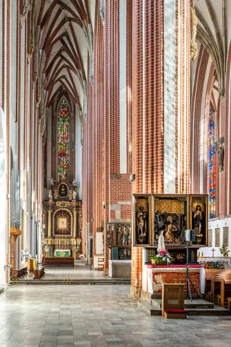 Ołtarz boczny przy ceglanym filarze w nawie wrocławskiego kościoła NMP na Piasku.