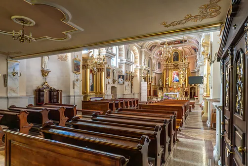Nawa główna bielskiej świątyni z drewnianymi ławkami i bocznymi ołtarzami.