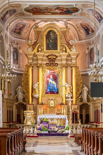Prezbiterium bazyliki w Hałcnowie ze złoconym ołtarzem głównym i polichromiami na sklepieniu.