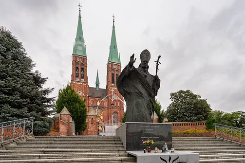 Pomnik papieża Jana Pawła II usytuowany przed schodami prowadzącymi do rybnickiej bazyliki.