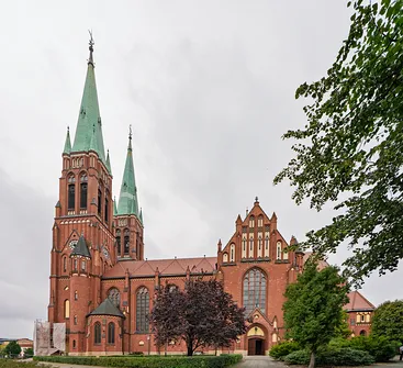 Elewacja boczna i transept ceglanej bazyliki św. Antoniego Padewskiego w Rybniku z widocznym portalem.